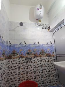 ein Bad mit einer Dusche mit Vögeln an der Wand in der Unterkunft Odyssey Stays Aalo in Along