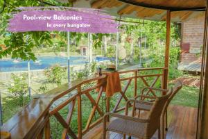 a porch with two chairs and a sign that reads poolview balconies in every at Phu Quoc Valley Sen Bungalow in Phu Quoc