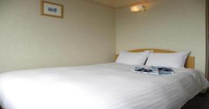 ein großes weißes Bett mit zwei Paar Schuhen drauf in der Unterkunft Yonezawa - Hotel / Vacation STAY 14342 in Yonezawa