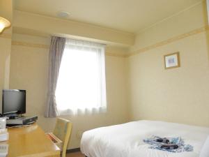 um quarto com uma cama, uma secretária e uma janela em Yonezawa - Hotel / Vacation STAY 14342 em Yonezawa
