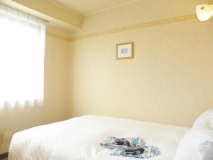 Yonezawa - Hotel / Vacation STAY 14342 في يونيزاوا: غرفة نوم عليها سرير وعليها حذاء