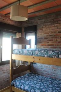1 dormitorio con 2 literas en una pared de ladrillo en Praia - Proa al Mar, en Maldonado