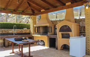 un patio con un horno al aire libre con una mesa en Amazing Home In Koroni With Wifi, en Koroni