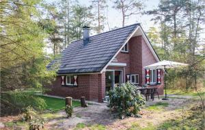 a small red brick house with a table and chairs at Vossenhol in Ommen