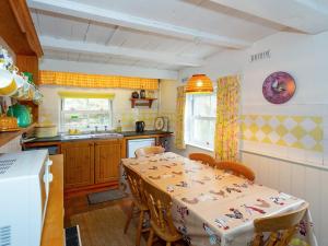 a kitchen with a table with chairs and a sink at Yellow - Uk43117 in Clynnog-fawr