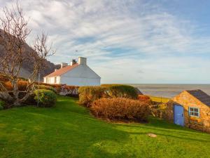 a white house on the shore of the ocean at Yellow - Uk43117 in Clynnog-fawr