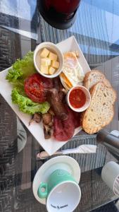 a plate of food with sausage cheese and bread at Full sea view Studio high floor in Ras al Khaimah