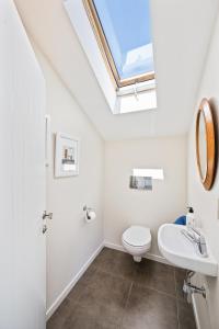 a bathroom with a toilet and a skylight at IRONSIDE LAKEVIEW TOWNHOUSE in Wanaka