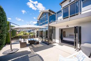 a patio with an umbrella and a bed in a building at IRONSIDE LAKEVIEW TOWNHOUSE in Wanaka