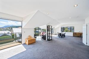a living room with white walls and large windows at IRONSIDE LAKEVIEW TOWNHOUSE in Wanaka