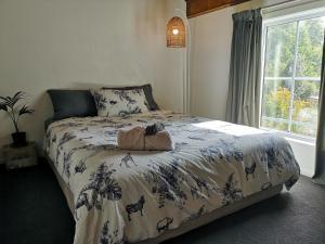 um quarto com uma cama com um urso de peluche em The Gisborne Club - Boutique accommodation em Gisborne