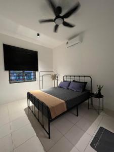 a bedroom with a bed with a ceiling fan at Tun Teja Homestay Jasin Melaka in Jasin