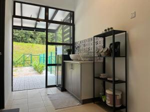 a kitchen with a door open to a patio at Tun Teja Homestay Jasin Melaka in Jasin