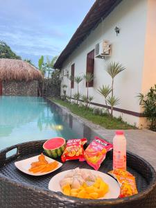 einen Tisch mit Essen darauf neben einem Pool in der Unterkunft Banyan Villa Nha Trang in Nha Trang