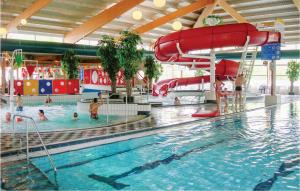 una piscina con un tobogán de agua y gente en el agua en Awesome Home In Vlagtwedde With Indoor Swimming Pool, en Vlagtwedde