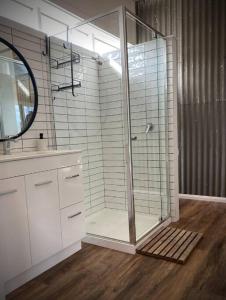 a bathroom with a shower with a glass door at Shiki Snow Cabin in Cobungra