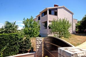 a house with a fence in front of it at Apartments Duda in Pula