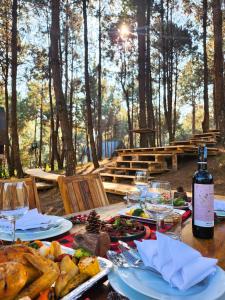 木州的住宿－The Nordic Village，餐桌,带食物盘和一瓶葡萄酒