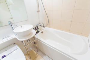 een badkamer met een wastafel, een bad en een toilet bij Hotel Nihonbashi Saibo in Tokyo
