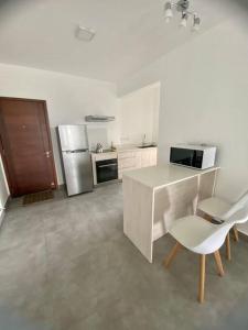 cocina blanca con encimera y nevera en Sandstone Apartment a walk to the beach, en Flic en Flac
