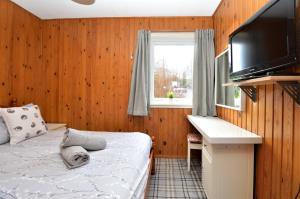 a bedroom with a bed and a desk and a television at Holy Loch Lodge in Hunters Quay
