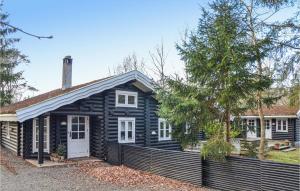 una casa negra con una puerta blanca y una valla en Pet Friendly Home In Hornbk With Kitchen, en Hornbæk