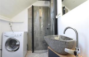 a bathroom with a sink and a washing machine at Ambjörby in Stöllet