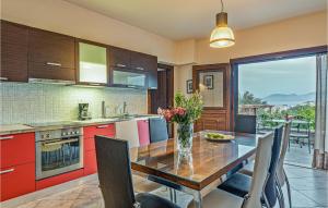 a kitchen with a table with a vase of flowers on it at Stunning Home In Kokari With Kitchen in Kokkari