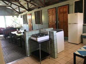 a kitchen with a stove and a refrigerator at Unu Pikin Guesthouse in Paramaribo