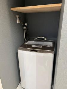 a washer and dryer sitting under a shelf at ZDT in Tokyo