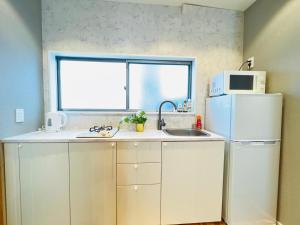 a kitchen with a white refrigerator and a microwave at ZDT in Tokyo
