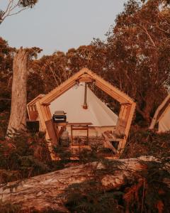 ein Zelt mit einem Tisch in der Mitte eines Feldes in der Unterkunft Numie - Freycinet Peninsula - Glamping in Coles Bay