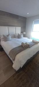 a large white bed in a room with a window at 67 Whale Rock Estate, Hermanus in Hermanus