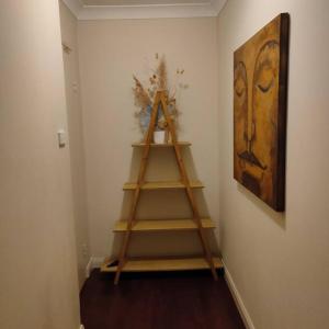 a wooden shelf in a room with a painting at Sunny 2 bed Restaurants beach at door Pets O.K in Sydney