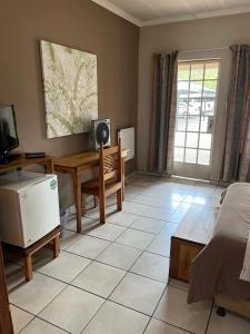 a room with a bed and a desk with a computer at Euforia Guesthouse in Middelburg