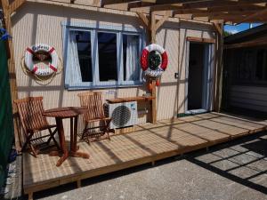 a deck with two chairs and a table and a fan at The Capitain's Cabin in Bluff