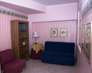 sala de estar con sofá azul y silla en Camere In Centro, en Agropoli