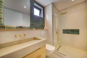 a bathroom with a sink and a toilet and a shower at Exclusive beachfront apartment in Belle Mare