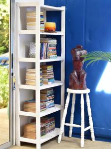 a book shelf filled with books next to a stool at Guesthouse Congo Tempisque in Liberia