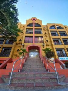 un edificio amarillo con escaleras delante en Apartamento dúplex vacacional cerca a la playa, en Gaira