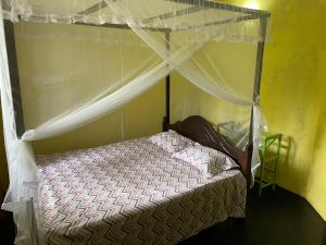 1 cama pequeña con dosel en una habitación en Mahiru Homestay, en Weligama