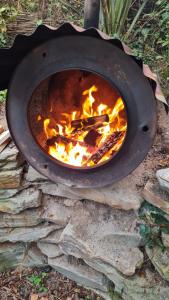 a grill with a fire inside of it at The Paddock Wildcamp in Perranporth