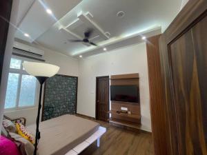a living room with a couch and a television at Lush Green Workation Villa - 1 Bedroom in Lucknow
