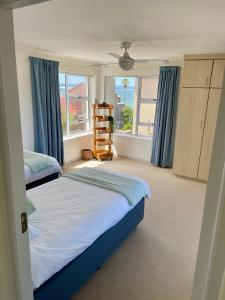 1 dormitorio con 2 camas y ventana grande en 'On Point' Beach House - Jeffreys Bay en Jeffreys Bay