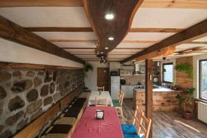 une cuisine et une salle à manger avec un mur en pierre dans l'établissement Guest House Kandaferi 2, à Elena