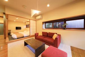 a living room with a couch and a bed at Fuji Onsenji Yumedono in Fujikawaguchiko