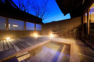 a patio with a table and chairs on a deck at Fuji Onsenji Yumedono in Fujikawaguchiko