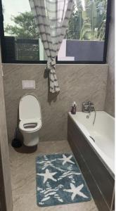 a bathroom with a tub and a toilet and a bath tub at Pisano Luxury Apartments in Lusaka