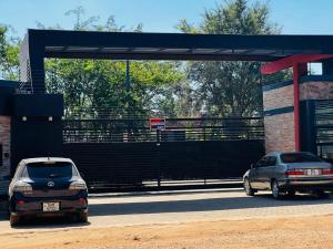 dos autos estacionados frente a una gasolinera en Pisano Luxury Apartments en Lusaka