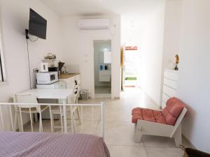 een witte kamer met een keuken, een tafel en een eetkamer bij אירוח ליד אילת compliment near Eilat in Beʼer Ora